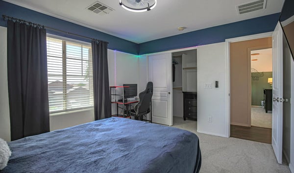 Comfortable guest bedroom with a spacious closet, soft carpeting, and large window providing excellent natural light. A functional and welcoming addition to this Waddell home.