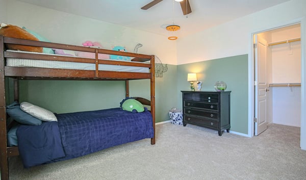 Well-appointed secondary bedroom featuring a walk-in closet, plush carpeting, and generous space for furniture. A versatile room designed for everyday comfort and organization.