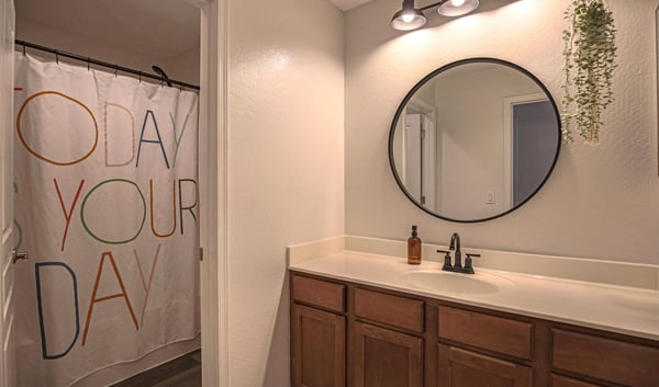 Bright secondary bedroom with plush carpeting, ceiling fan, generous natural light, and space for a desk or workspace. A versatile room perfect for family, guests, students, or working from home.