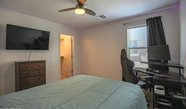 Spacious bedroom featuring soft carpeting, ceiling fan, and abundant natural light. This flexible room adapts easily as a guest room, teen suite, or dedicated workspace.