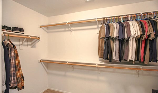 Generous walk-in closet with multiple clothing rods and abundant storage capacity, creating an organized and functional extension of the spacious primary suite.