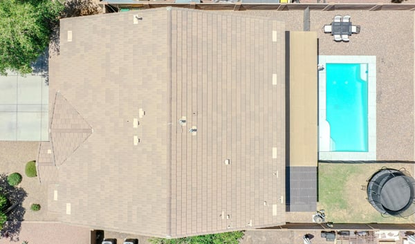 Bird's-eye view showcasing the property's backyard with a sparkling pool, covered patio, lawn area, and low-maintenance landscaping. An excellent aerial perspective of this Waddell home's outdoor amenities.