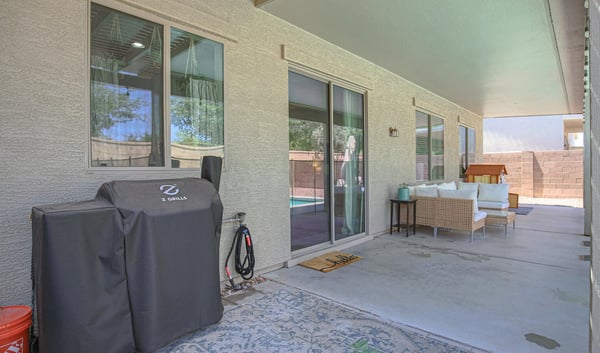 Large covered patio offering comfortable seating, shade, and seamless access to the backyard pool area. Perfect for outdoor gatherings and everyday living in this Waddell home.