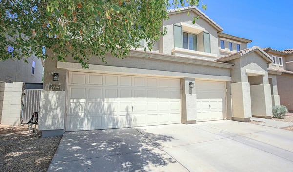 Charming front exterior showcasing a three-car garage, mature landscaping, and inviting covered entry. This attractive Waddell property offers excellent curb appeal and functional everyday convenience.
