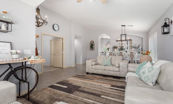 Featuring vaulted ceilings, abundant windows, updated flooring, and an open layout, this bright living room provides the perfect place to relax, entertain, or spend time with family.