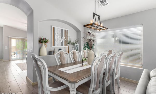Gather family and friends in this spacious dining room featuring vaulted ceilings, designer lighting, updated flooring, and an open-concept layout that connects beautifully with the home's main living areas.
