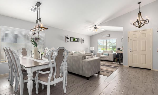 The open floor plan effortlessly connects the dining and living areas, creating an inviting atmosphere enhanced by modern flooring, designer lighting, and abundant natural light throughout.