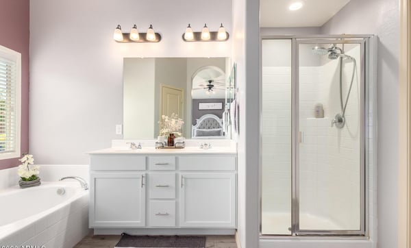 Enjoy a bright primary bathroom complete with dual vanities, a soaking tub, separate walk-in shower, and modern finishes that provide comfort and functionality for everyday living.