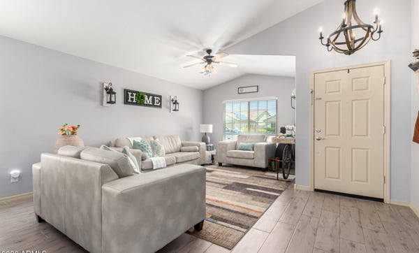 Bright windows, vaulted ceilings, updated flooring, and tasteful finishes make this inviting living room an ideal space for relaxing while enjoying the home's open-concept design.