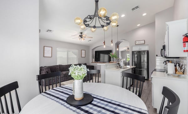 The open dining area overlooks the modern kitchen and spacious family room, creating an ideal layout for entertaining. Updated lighting, soaring ceilings, and contemporary finishes enhance the home's appeal.