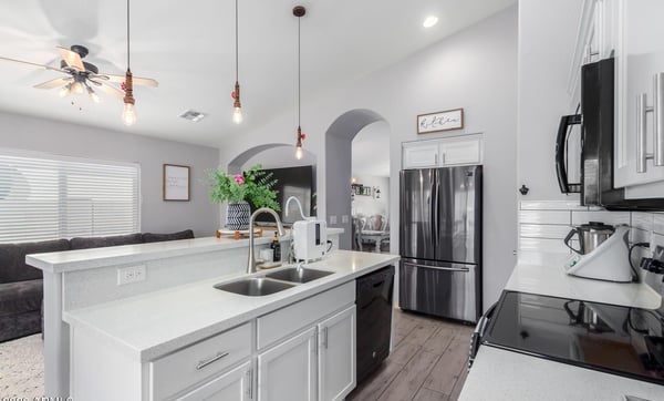White quartz countertops, crisp white cabinetry, a spacious breakfast bar, and an open floor plan make this stylish kitchen the heart of the home. Perfect for entertaining and everyday living.