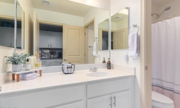 The guest bathroom offers a spacious vanity with white cabinetry, ample storage, and a full tub and shower combination. Bright finishes create a fresh, move-in-ready feel.