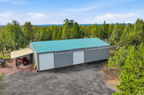 Spacious workshop and additional 3-bay nestled among trees, perfect for storage or hobby projects.