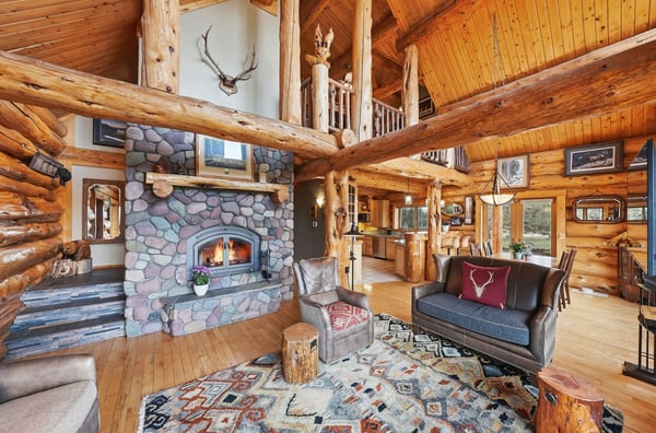 Experience rustic luxury in this spacious log home, featuring a stunning stone fireplace and an inviting open layout.