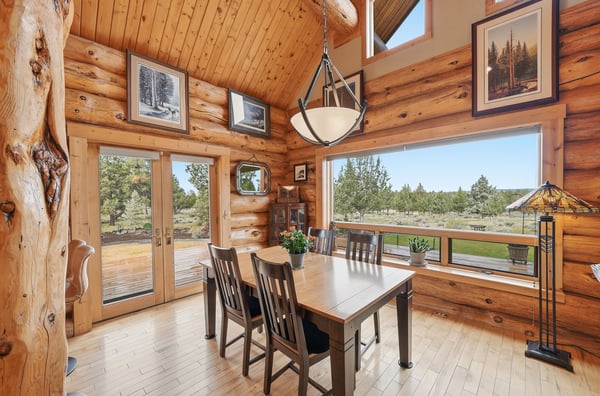 Discover this inviting log cabin dining area, featuring panoramic views and a warm, natural ambiance.