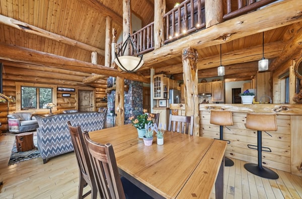 Rustic log cabin with spacious open concept living area, modern kitchen, and inviting dining space.