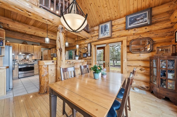 Enjoy the warmth of this inviting log cabin featuring a spacious dining area and modern kitchen amenities.