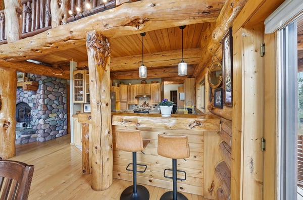 This rustic home features wooden beams and a cozy kitchen bar, ideal for casual gatherings.