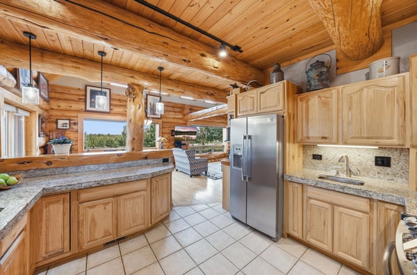 Inviting space featuring natural wood beams, granite countertops, and an open layout perfect for entertaining.