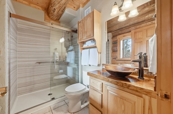 Modern bathroom with walk-in shower featuring a glass shower, wooden accents, and ample natural light for a refreshing feel.