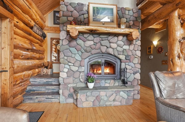 This inviting living space features a stunning stone fireplace and rich wooden accents for a cozy atmosphere.