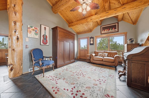 Warm and inviting living space featuring natural wood accents, large windows, and a cozy seating arrangement.