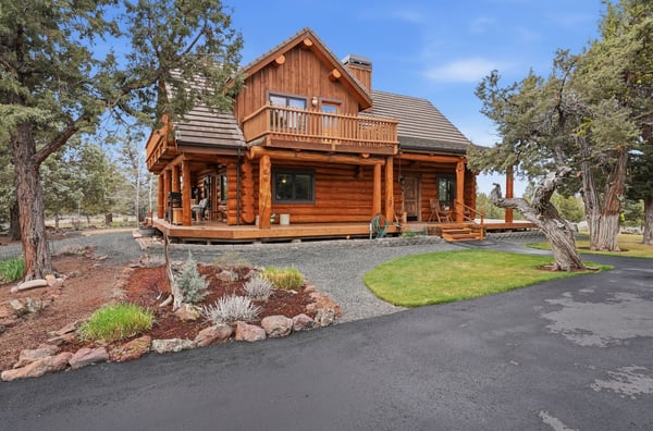 Experience modern rustic living in this stunning log home, surrounded by nature and vibrant landscaping.