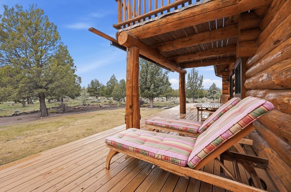 Enjoy relaxing moments on the spacious deck of this rustic log cabin, surrounded by nature's beauty.