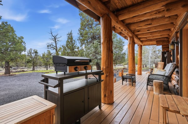 Spacious outdoor deck with a grilling area, surrounded by nature, perfect for entertaining and relaxation.