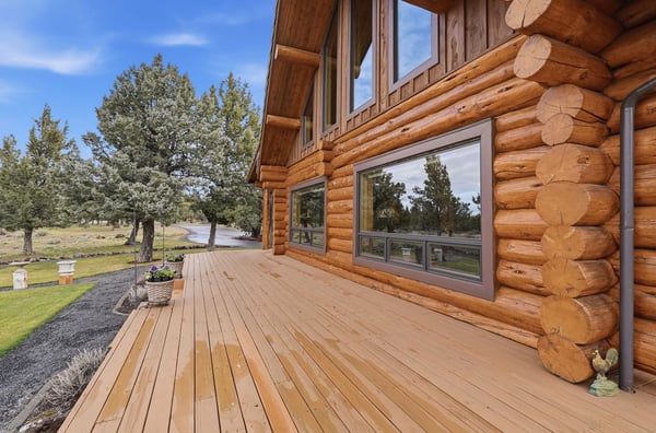 Spacious log home features an expansive deck with scenic views, perfect for outdoor gatherings and relaxation.