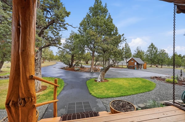 Nestled amid lush greenery, this property features a spacious driveway and beautifully landscaped grounds.