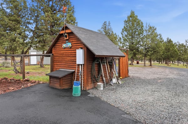 Cozy storage shed with ample space for tools and equipment, surrounded by a spacious, gravel yard.