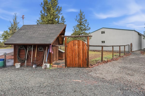 Distinctive outdoor space featuring a rustic entrance, storage shed, and ample room for hobbies or livestock.