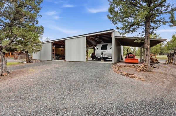 Spacious covered parking with ample room for vehicles and equipment, set among lush, scenic surroundings.