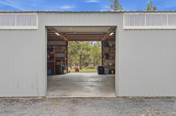 The spacious, open shop/garage offers ample storage and workspace, with stunning natural views just outside.