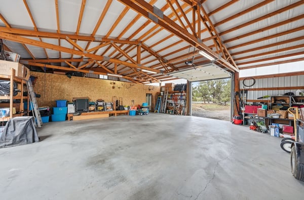 Spacious garage with ample storage and high ceilings, perfect for hobbies or vehicle storage.