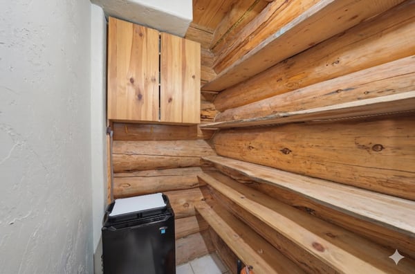 Spacious storage pantry with wooden shelves and convenient appliance space, perfect for organizing essentials.
