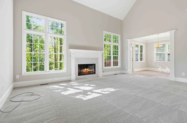 Bright, airy living space featuring large windows, a cozy fireplace, and abundant natural light.