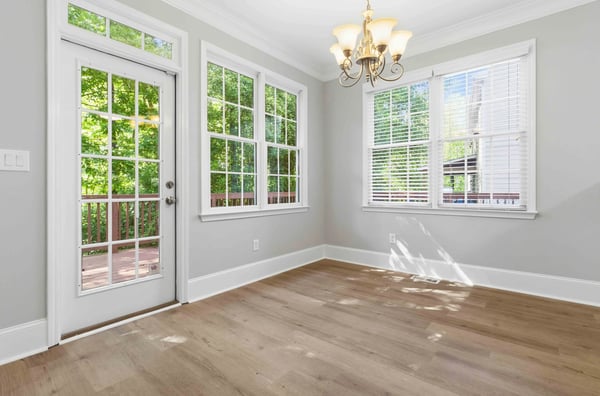 Bright breakfast nook featuring large windows, natural light, and direct access to an outdoor deck. (Virtual Staging)
