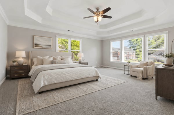 Spacious primary suite featuring high ceilings, abundant natural light, and a cozy reading nook. (Virtual Staging)
