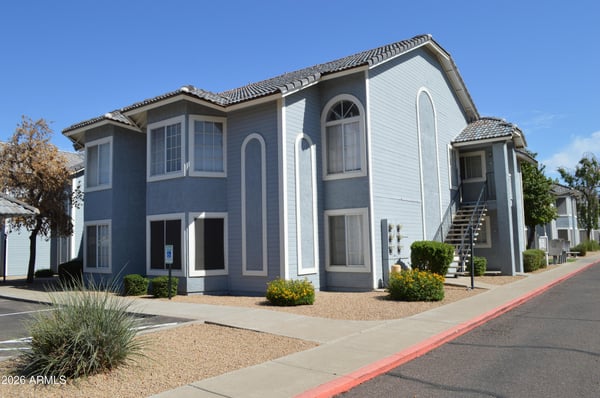 Exterior view highlighting attractive landscaping, manicured grounds, and convenient parking within the community. This Phoenix property combines updated interiors with an appealing residential environment.