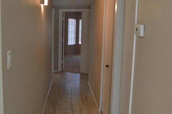 Freshly updated hallway with modern tile flooring, neutral finishes, and contemporary lighting leading to the home's bedrooms and bathrooms. Every detail reflects the quality renovations throughout this Phoenix property.