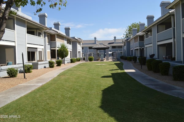 Scenic community grounds with manicured lawns, mature landscaping, and walking paths leading throughout the neighborhood. These attractive outdoor spaces enhance the appeal of this Phoenix home.