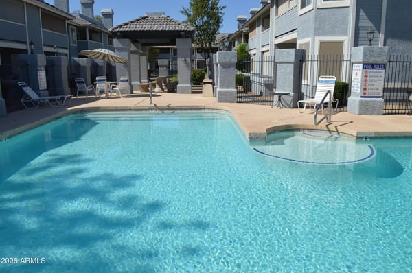 Beautiful community pool featuring a spacious sun deck, lounge chairs, and inviting outdoor spaces. Residents can enjoy relaxing resort-style amenities in this well-kept Phoenix neighborhood.