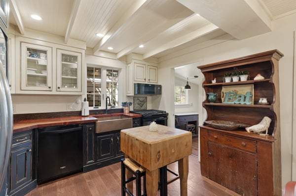 Bright and functional kitchen featuring modern appliances, a rustic island, and warm wooden accents.