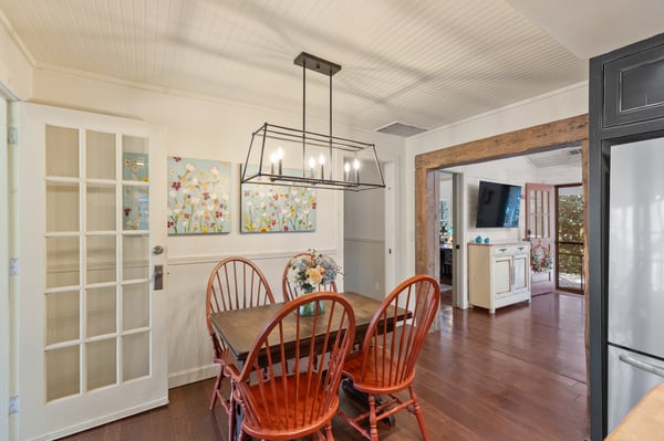 Bright dining area featuring a unique light fixture and easy access to the inviting living space.