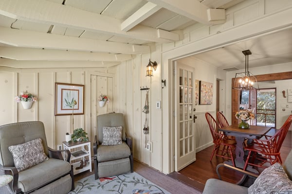 Cozy living area with rustic beams, inviting décor, and a seamless transition to the dining space.