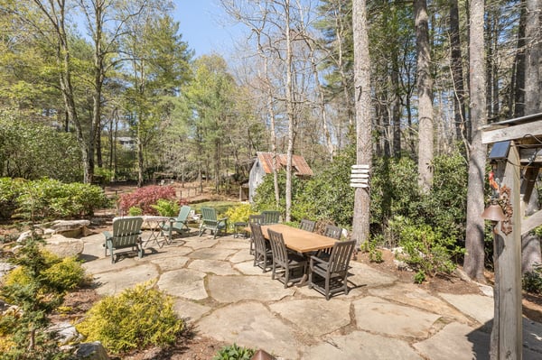 Discover a spacious outdoor patio surrounded by lush greenery, perfect for entertaining and enjoying nature.