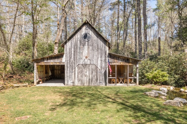 Discover a unique rustic barn surrounded by lush greenery, perfect for outdoor gatherings and projects.