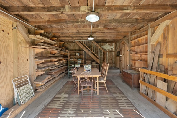 Spacious wooden interior featuring ample shelving, a rustic dining area, and potential for creative use.